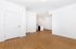 Bright and modern apartment interior featuring sleek hardwood floors and a stylish open-concept kitchen area with pendant lighting.