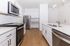 Sleek, modern kitchen featuring stainless steel appliances, elegant white cabinetry, and a chic island with dual sinks.