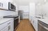 Modern kitchen with sleek stainless steel appliances, ample white cabinetry, and elegant hardwood flooring for a polished look.