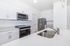 Modern kitchen with sleek stainless steel appliances, pristine white cabinetry, and elegant quartz countertops.