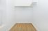 Spacious and bright walk-in closet with elegant wooden flooring and ample storage potential.