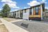 Charming apartment complex with modern design, featuring large windows and inviting exterior surrounded by greenery.