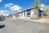 Charming apartment building with modern exterior, surrounded by open parking and beautiful blue skies.