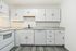 Modern kitchen with sleek white cabinets, marble countertops, and stainless steel appliances.