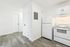 Bright, modern kitchen with sleek white cabinets, stainless steel appliances, and stylish wood-look flooring.