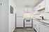 Bright modern kitchen with sleek white cabinetry, marble countertops, and stainless steel appliances.