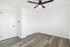Bright and spacious room with modern ceiling fan, elegant hardwood flooring, and ample closet space, exuding simplicity and comfort.