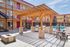 Vibrant apartment courtyard featuring a modern pergola, cozy fire pit, outdoor dining area, and sparkling pool.