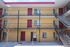 Bright and welcoming apartment complex with modern steel staircases, vibrant red doors, and serene courtyard setting.