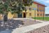 Charming apartment complex with vibrant exterior, surrounded by lush greenery and pathways.