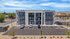 Modern three-story apartment building with balconies, ample parking, and scenic views, capturing urban living at its finest.