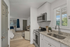 Modern kitchen with sleek granite countertops, stainless steel appliances, and a bright, airy view into the cozy open-plan living space.