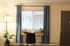 Cozy workspace with a modern desk, blue curtains, and stylish decor in a bright, inviting room.