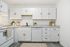 Modern kitchen with sleek white cabinetry, elegant countertops, and integrated appliances for a stylish cooking experience.