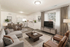 Modern living room with elegant decor, featuring a comfortable gray sofa, stylish wooden coffee table, and integrated dining area adjacent to a bright, cozy kitchen.