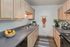 Charming kitchen with elegant cabinetry, sleek countertops, lush plants, and vibrant fruit display.