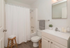 Elegant bathroom with modern fixtures, featuring a sleek vanity, decorative plant, and cozy atmosphere.