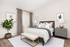 Elegant bedroom with a plush bed, chic decor, and abundant natural light, featuring neutral tones and stylish furnishings.