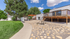 Charming outdoor area with lush greenery, spacious patio, and elegant wooden pergola for relaxation and entertainment.