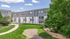 Charming modern apartment building with lush green landscaping and a serene walkway.
