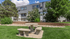 Charming apartment exterior with a beautifully landscaped garden and elegant stone bench set, perfect for outdoor relaxation.