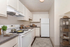 Bright, functional kitchen with modern white cabinets, sleek countertops, and stylish decor, offering a welcoming space for meal preparation.