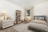 Charming and cozy bedroom with modern decor, featuring a plush bed, elegant bookshelf, and a stylish dresser in a serene neutral palette.