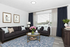Chic and bright living room featuring elegant dark sofas, a glass coffee table adorned with fresh flowers, and large windows with stylish curtains.