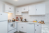 Modern kitchen with sleek white cabinets, elegant tile backsplash, and stainless appliances, perfect for culinary creativity.