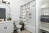 Modern bathroom with elegant fixtures, featuring a sleek vanity, framed mirror, and chic shower with patterned curtain.