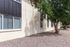 Charming apartment exterior with modern brick facade, large windows, and mature trees creating a tranquil setting.