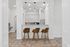 Modern kitchen nook with elegant bar seating, sleek pendant lighting, and pristine white cabinetry, perfect for stylish gatherings.