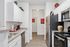 Contemporary kitchen with sleek stainless steel appliances, elegant white cabinetry, and stylish decor accents.