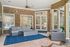 Inviting outdoor patio with stylish wicker seating, modern stone accents, and elegant French doors, perfect for entertaining.