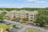 Charming apartment complex surrounded by lush greenery, featuring spacious balconies and ample parking.