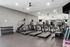 Modern fitness center featuring state-of-the-art treadmills, step machine, mirrors, and a rack of dumbbells for a complete workout experience.