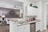 Modern apartment interior showcasing an elegant open kitchen with sleek white cabinetry, a stainless steel dishwasher, and a cozy living room with stylish decor accents.