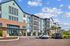 Modern apartment building with stylish design and spacious balconies under a clear blue sky.