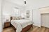 Bright and inviting bedroom with large window, cozy bed, and elegant decor in a modern apartment setting.