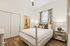 Inviting bedroom with elegant four-poster bed, soft lighting, and stylish decor, featuring hardwood floors and an en-suite bathroom.