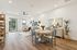 Bright and inviting open-plan living and dining area with elegant decor, featuring stylish wooden flooring, contemporary furniture, and abundant natural light from large windows.
