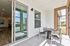 Charming outdoor patio with modern furniture, offering a serene view of the water from a stylish apartment.