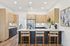 Contemporary kitchen with sleek cabinetry, stainless steel appliances, and a stylish breakfast bar with plush seating.