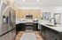 Modern kitchen with sleek stainless steel appliances, stylish light wood cabinets, and elegant countertops, offering a welcoming and functional cooking space.