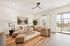 Bright and cozy living room with stylish furniture, elegant decor, and large window offering ample natural light.