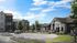 Charming apartment community with modern architecture, vibrant landscaping, and a welcoming leasing office under a clear blue sky.