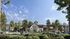 Charming residential complex surrounded by lush greenery and vibrant community life under a clear blue sky.