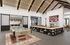 Modern entertainment room featuring a stylish pool table, cozy seating around a double-sided fireplace, and high vaulted ceilings for a spacious feel.