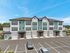 Contemporary multi-story apartment building with modern facade and dedicated parking in a serene setting.