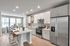Modern kitchen with sleek stainless steel appliances, spacious island, and elegant dining area. Bright natural lighting enhances the clean, contemporary design.